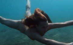 Julia is swimming underwater nude in the sea